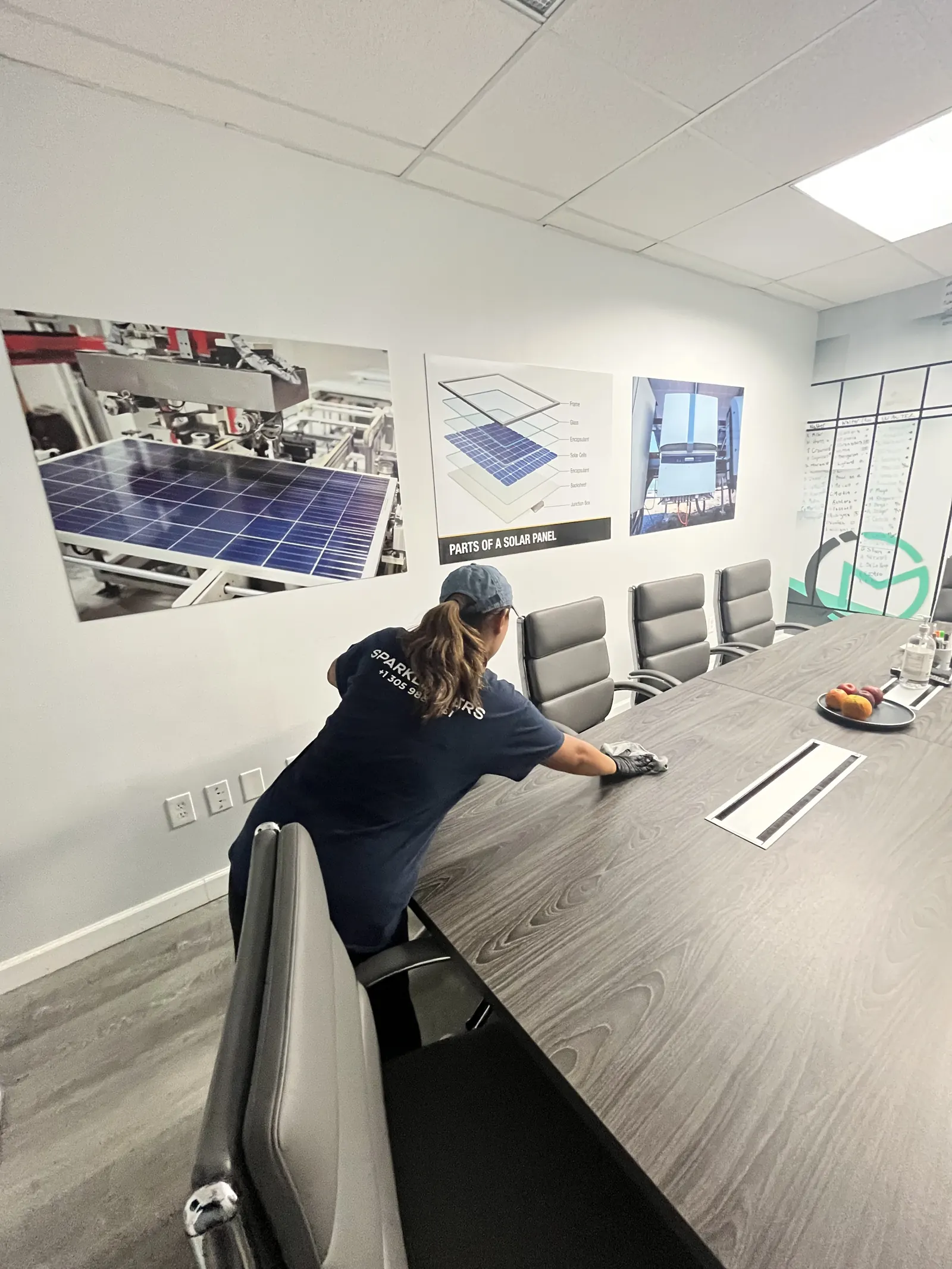 Sparkleaners cleaner wiping down a conference room table in a South Florida office